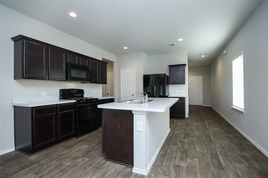 4023 Wyanngate Drive Spring, TX 77373 - Photo 7 of 23 a kitchen with kitchen island stainless steel appliances a sink dishwasher a refrigerator and a stove top oven with wooden floor
