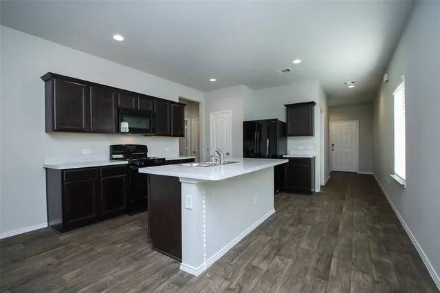 a view of kitchen with refrigerator stove microwave and cabinets