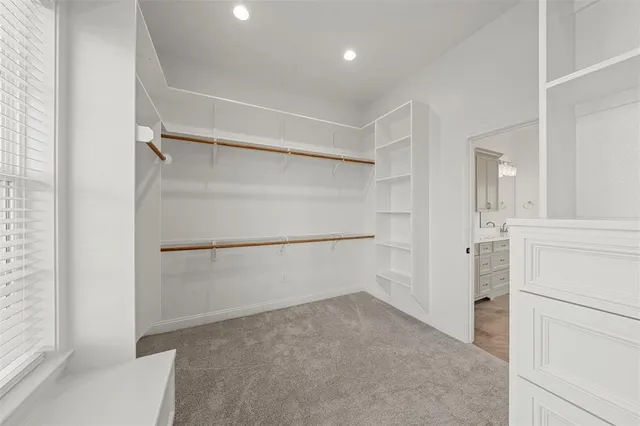 a view of walk in closet with empty racks