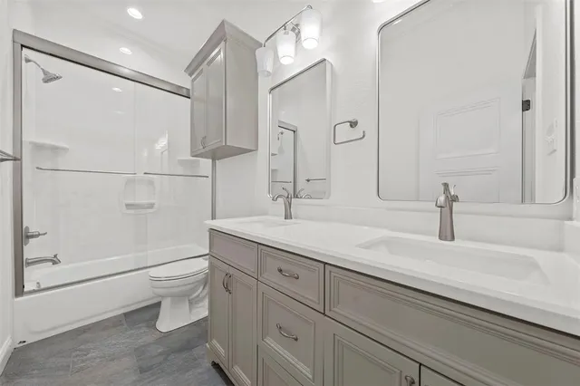 a bathroom with a double vanity sink toilet and shower