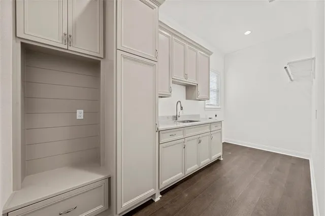 a bathroom with a granite countertop sink and white cabinets
