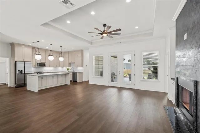 a large kitchen with lot of cabinets and wooden floor
