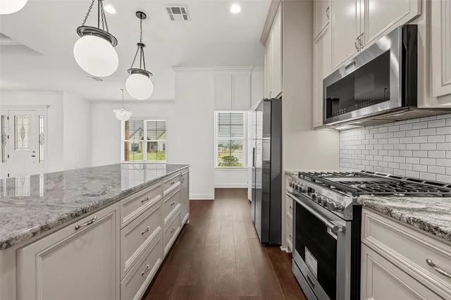 a kitchen with stainless steel appliances granite countertop a stove and a microwave