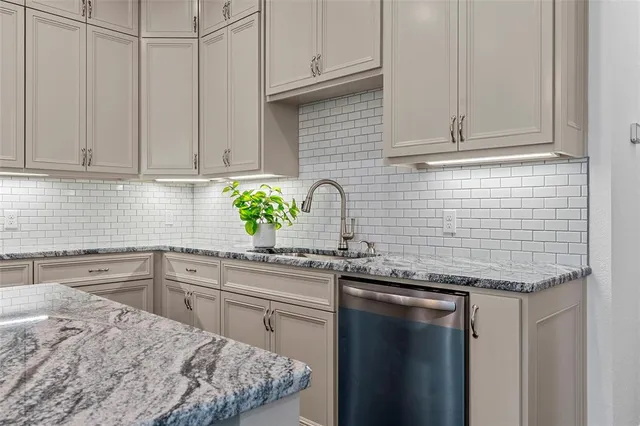 a kitchen with stainless steel appliances granite countertop a sink a stove and cabinets
