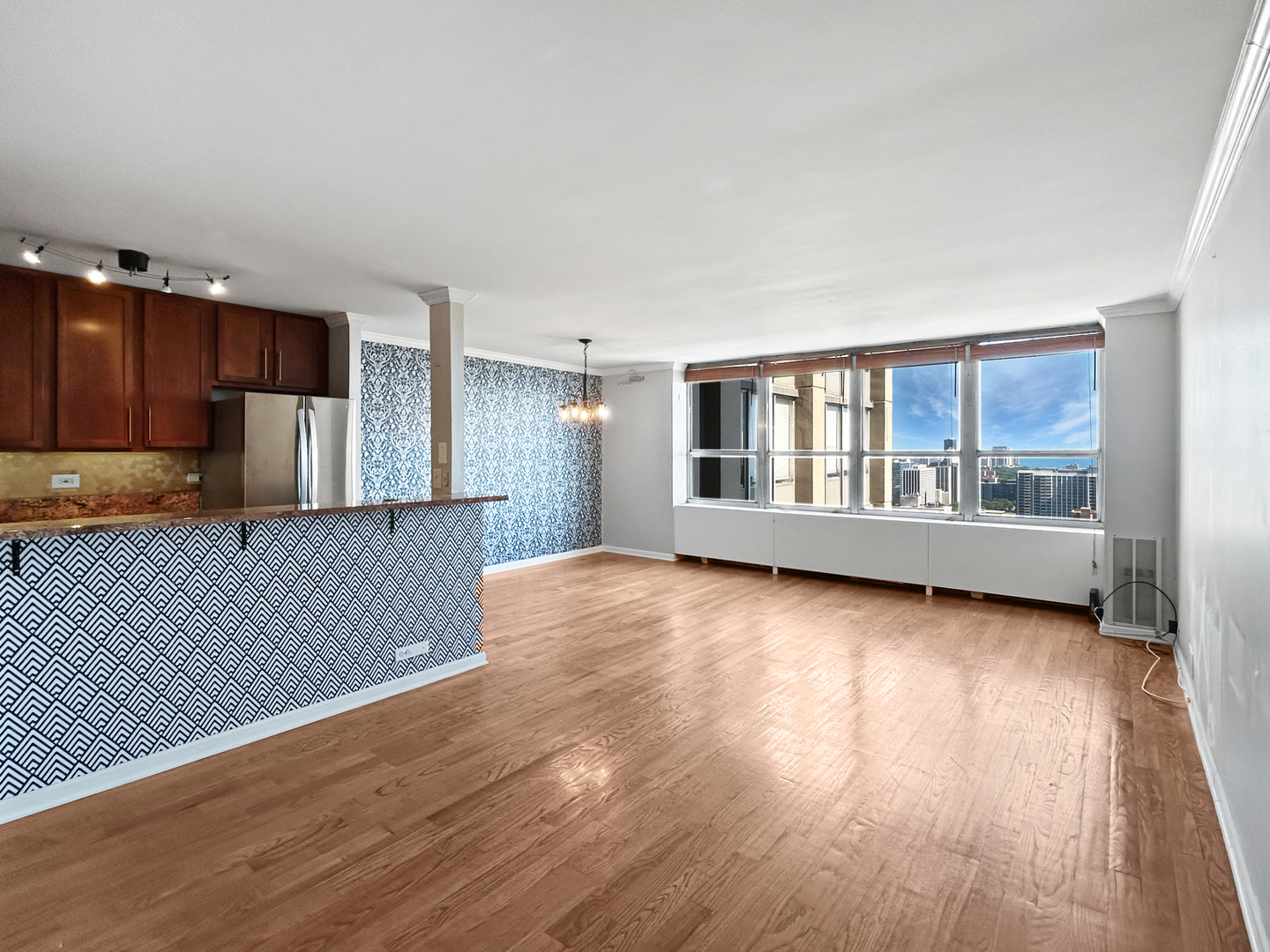 655 West Irving Park Road, Unit 3608 Chicago, IL 60613 - Photo 8 of 20 a view of an empty room with wooden floor and a window