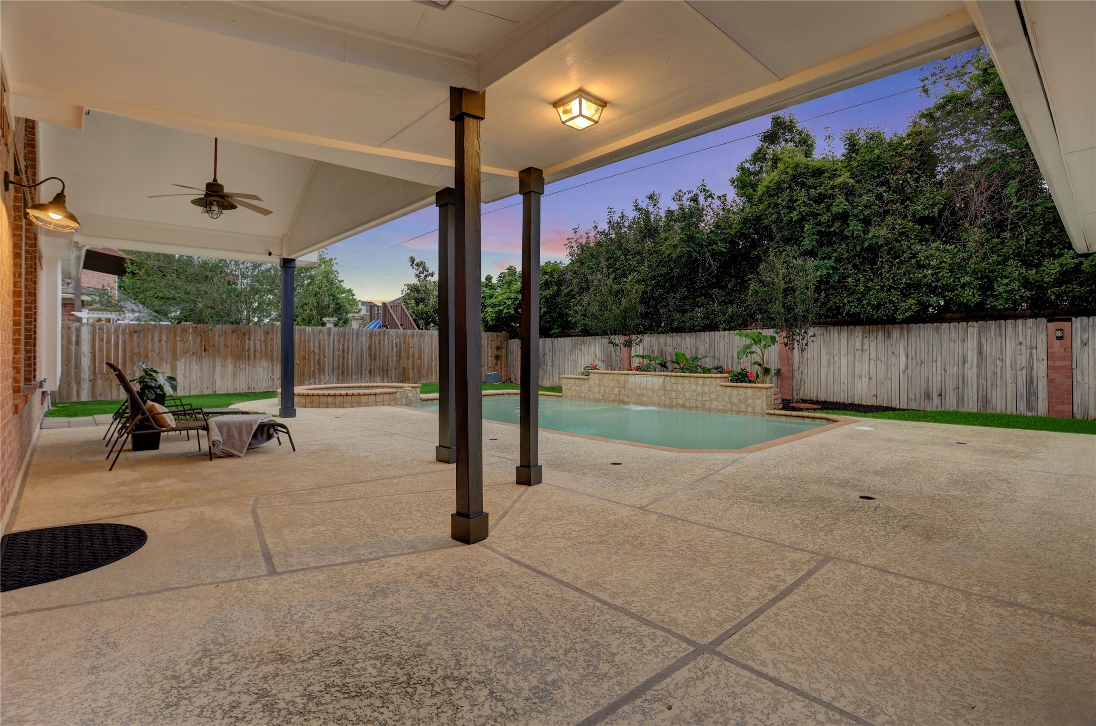 24418 Falcon Point Drive Katy, TX 77494 - Photo 30 of 40 Expansive covered patio designed for year-round enjoyment, offering ample space for lounging, dining, and entertaining. Imagine evenings under the ceiling fan, relaxing with friends while overlooking your private pool and backyard retreat.