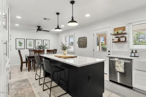 a kitchen with stainless steel appliances kitchen island a dining table and chairs