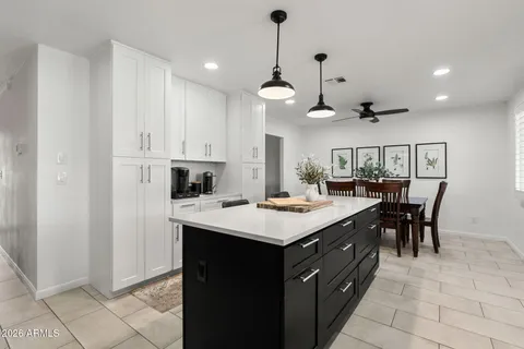 a kitchen with kitchen island a sink table and chairs