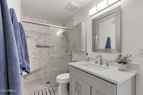 a bathroom with a sink a toilet and shower