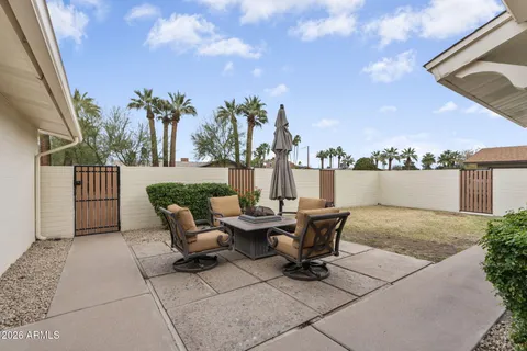 a roof deck with table and chairs and potted plants