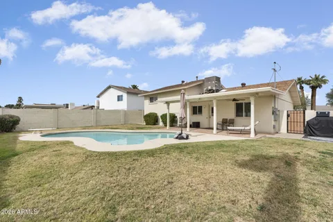 a view of a house with swimming pool and a yard