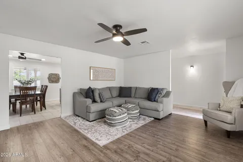 a living room with furniture and a wooden floor