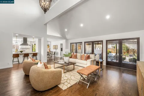 a kitchen with stainless steel appliances granite countertop a stove a sink a oven a dining table with chairs and white cabinets