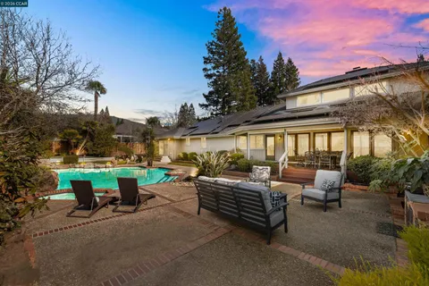 a view of a patio with couches table and chairs and potted plants