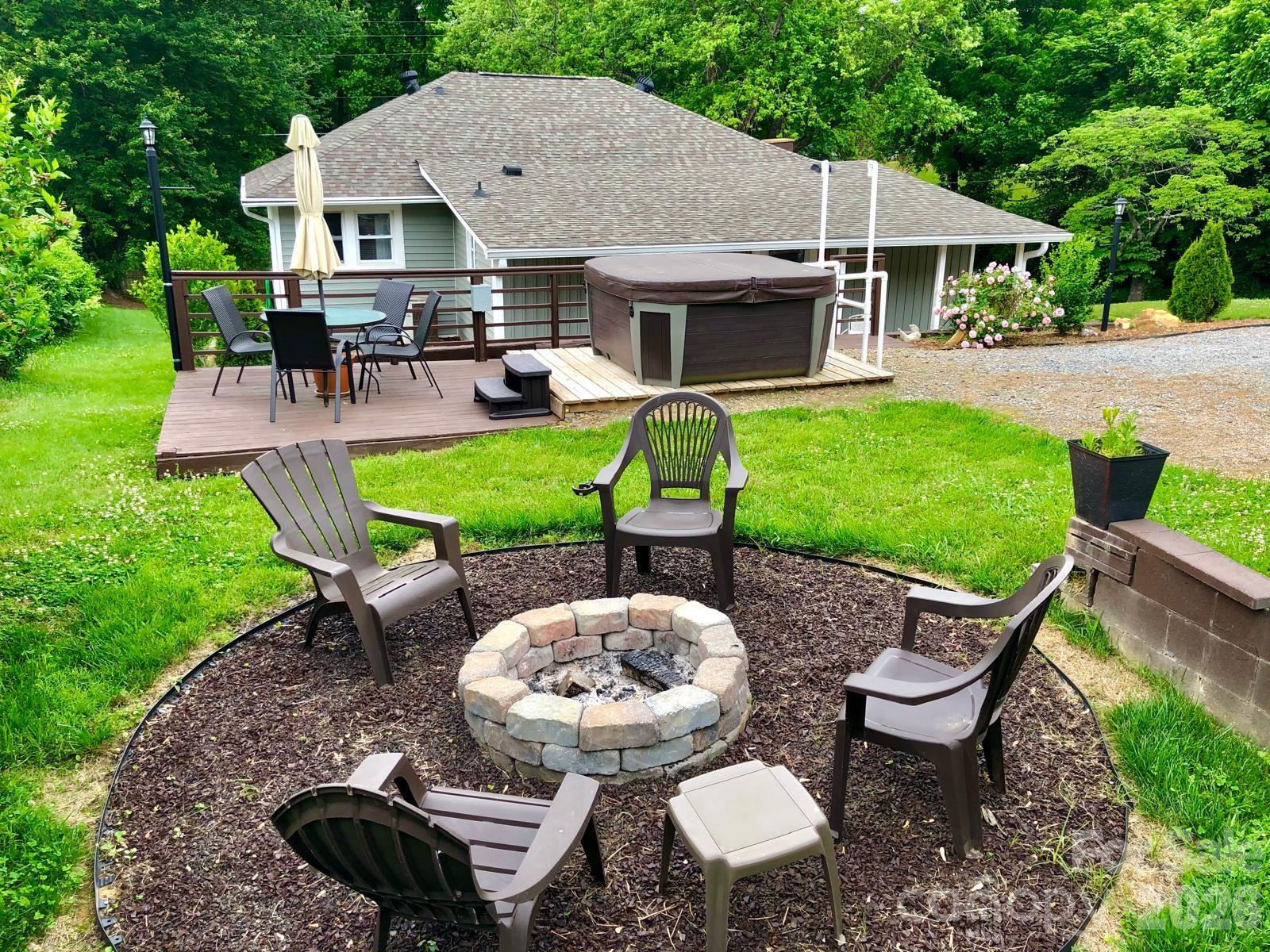 23 Maxwell Road Asheville, NC 28805 - Photo 45 of 47 a view of a patio with table and chairs potted plants and a palm tree