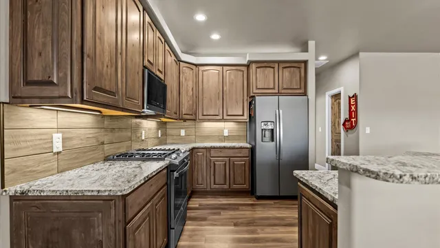 a kitchen with stainless steel appliances granite countertop cabinets and refrigerator