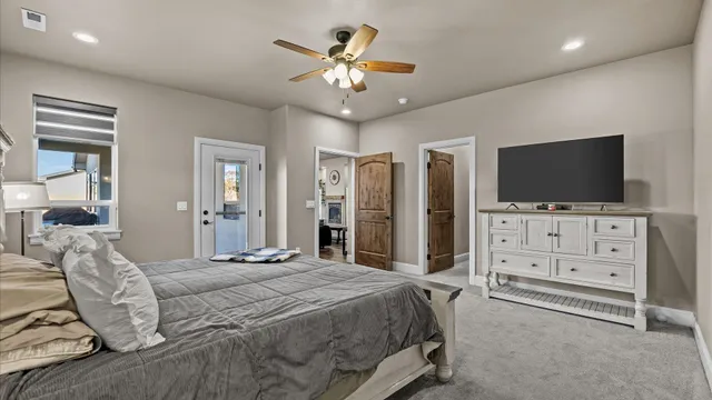 a bedroom with a bed a flat screen tv and a chandelier