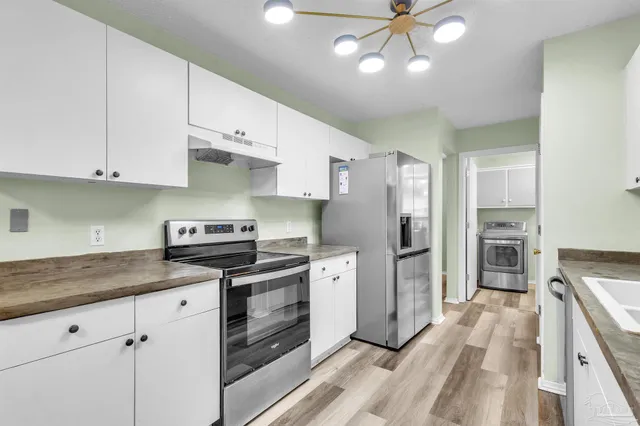a kitchen with a stove a refrigerator and a sink