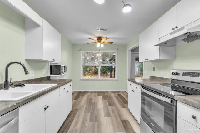 a kitchen with a sink stove and cabinets