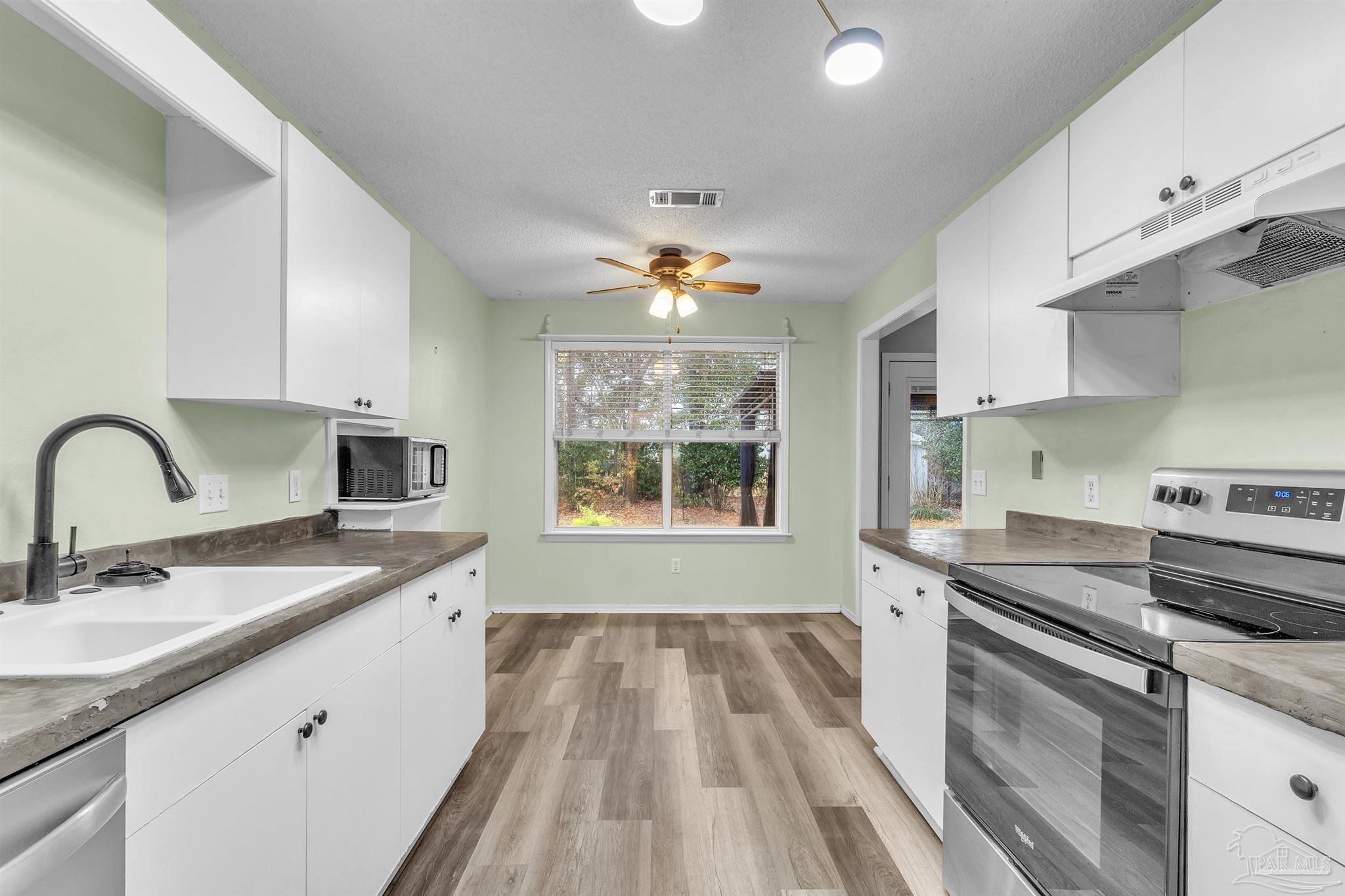 4331 Chantilly Way Milton, FL 32583 - Photo 12 of 30 a kitchen with a sink stove and cabinets