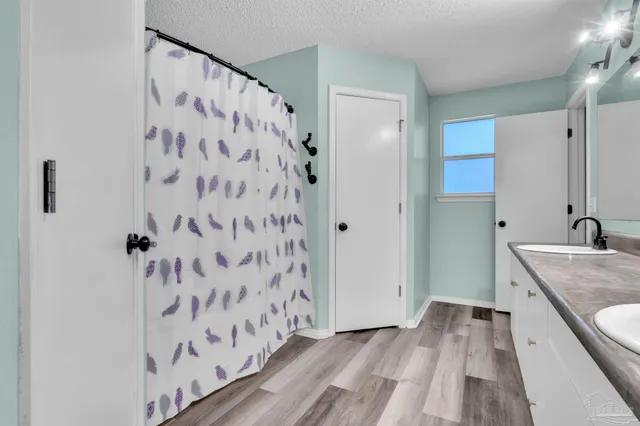 a bathroom with a granite countertop shower curtain and a sink