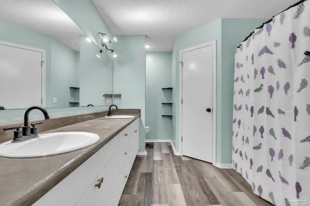 a bathroom with a double vanity sink mirror and shower