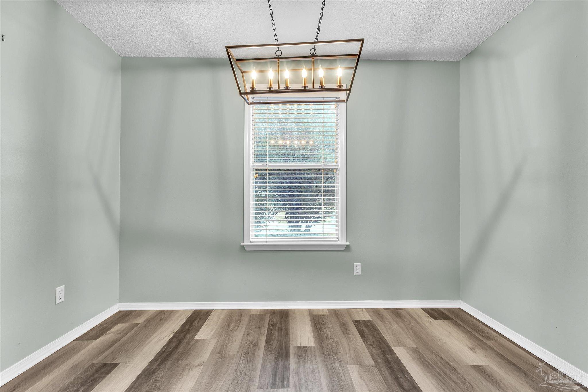4331 Chantilly Way Milton, FL 32583 - Photo 8 of 30 a view of an empty room with wooden floor and a window