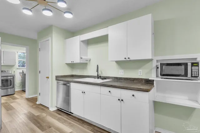 a kitchen with granite countertop a sink stove and cabinets