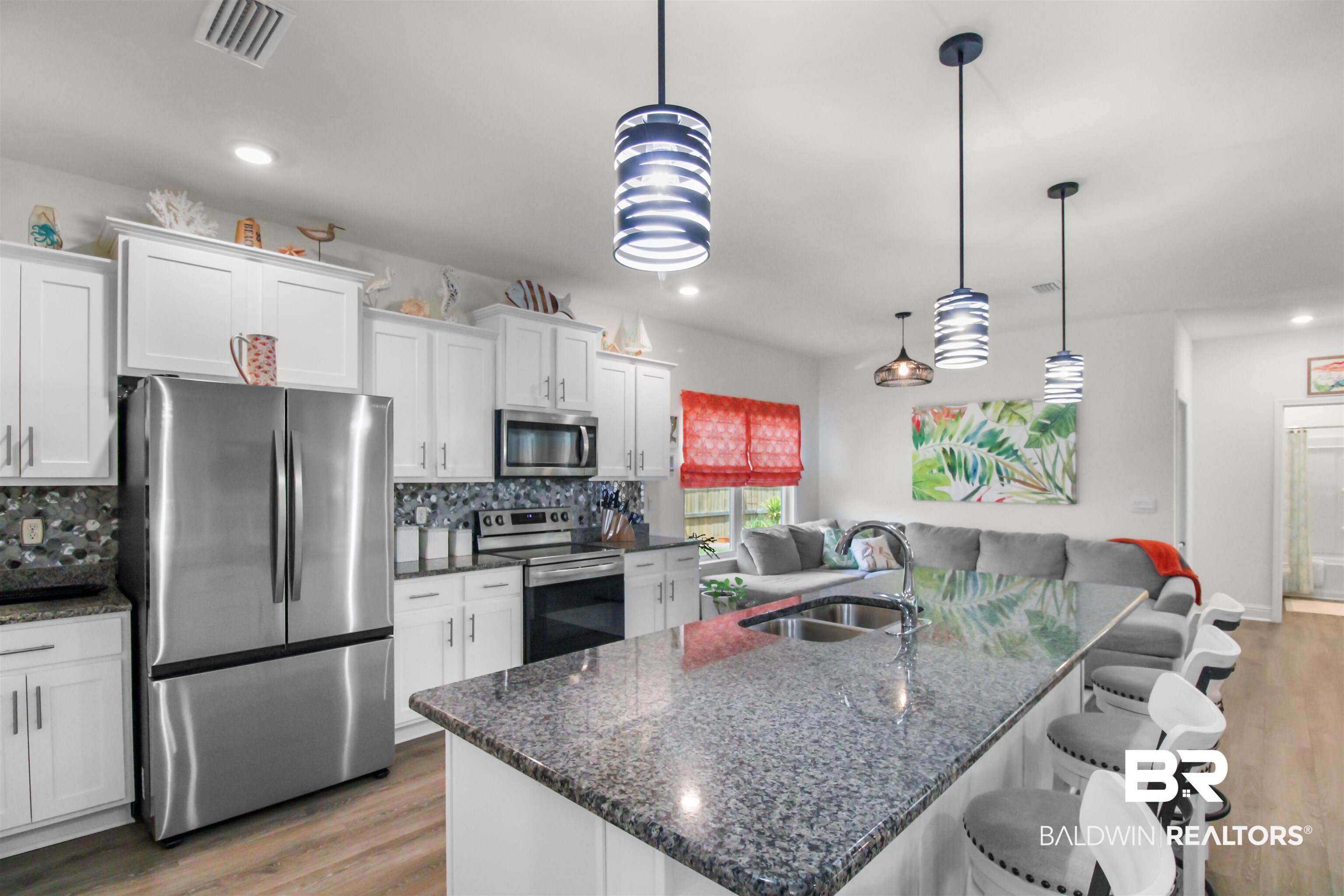 1885 Carly Street Foley, AL 36535 - Photo 11 of 40 Kitchen featuring white cabinetry, stainless steel appliances, a mosaic tile backsplash, and an island with a stone-finish countertop