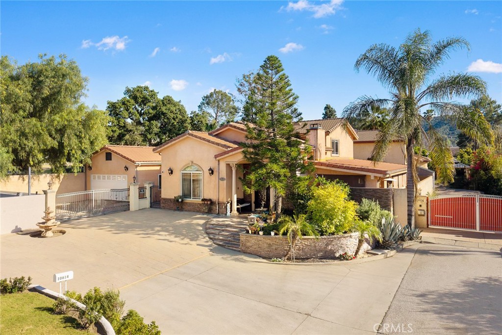 10610 Oak Tree Way Sunland, CA 91040 - Photo 7 of 63 a view of a white house with a large tree and plants