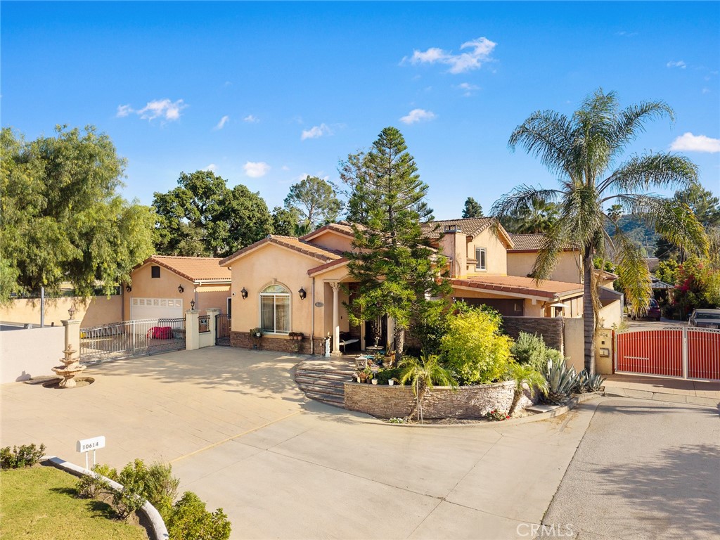 10610 Oak Tree Way Sunland, CA 91040 - Photo 8 of 63 a view of a white house with a large tree and yard in front of it