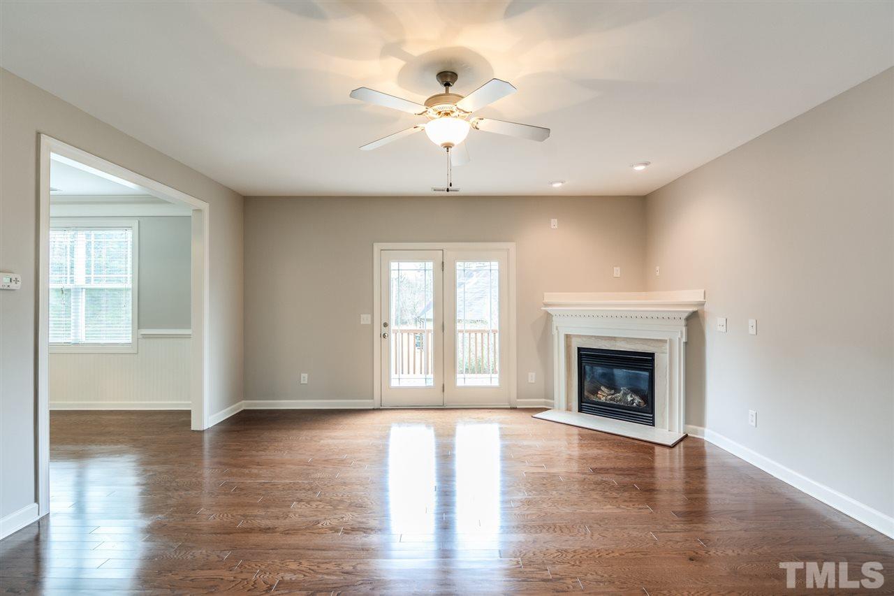 3630 Eastern Branch Road Raleigh, NC 27610 - Photo 5 of 25 a view of an empty room with wooden floor fireplace and a window