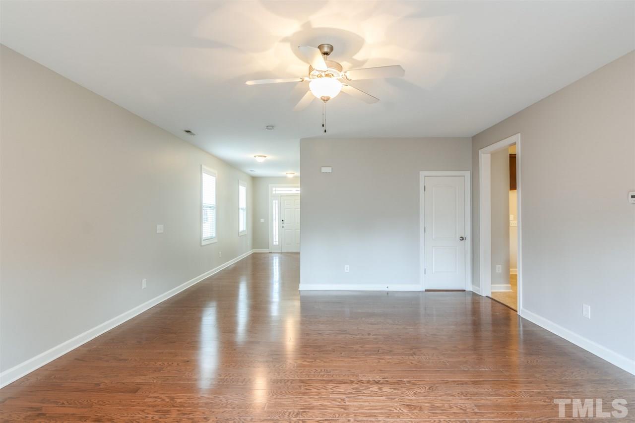 3630 Eastern Branch Road Raleigh, NC 27610 - Photo 9 of 25 a view of an empty room with wooden floor and a ceiling fan
