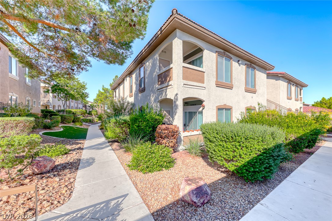 2305 West Horizon Ridge Parkway, Unit 3621 Henderson, NV 89052 - Photo 1 of 23 A Mediterranean-inspired building, featuring graceful arches and a covered balcony, is nestled amid verdant landscaping and a well-maintained pathway.