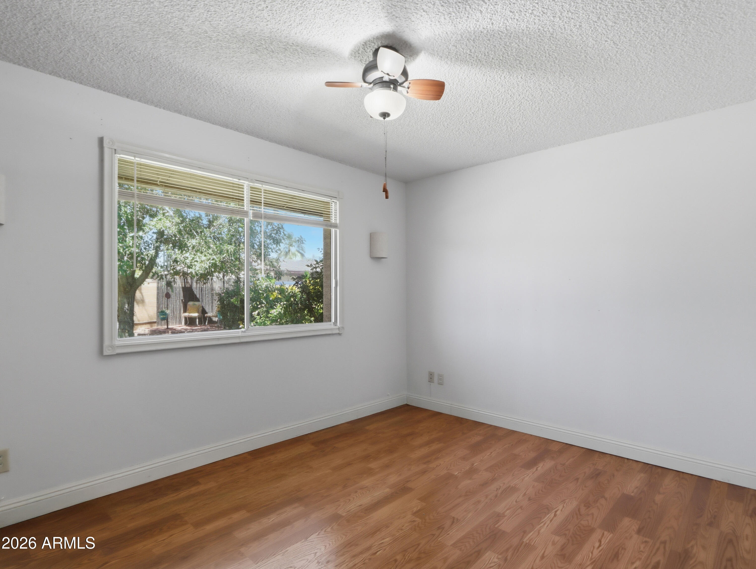 450 Cascada Road Litchfield Park, AZ 85340 - Photo 24 of 40 a view of empty room with wooden floor and fan