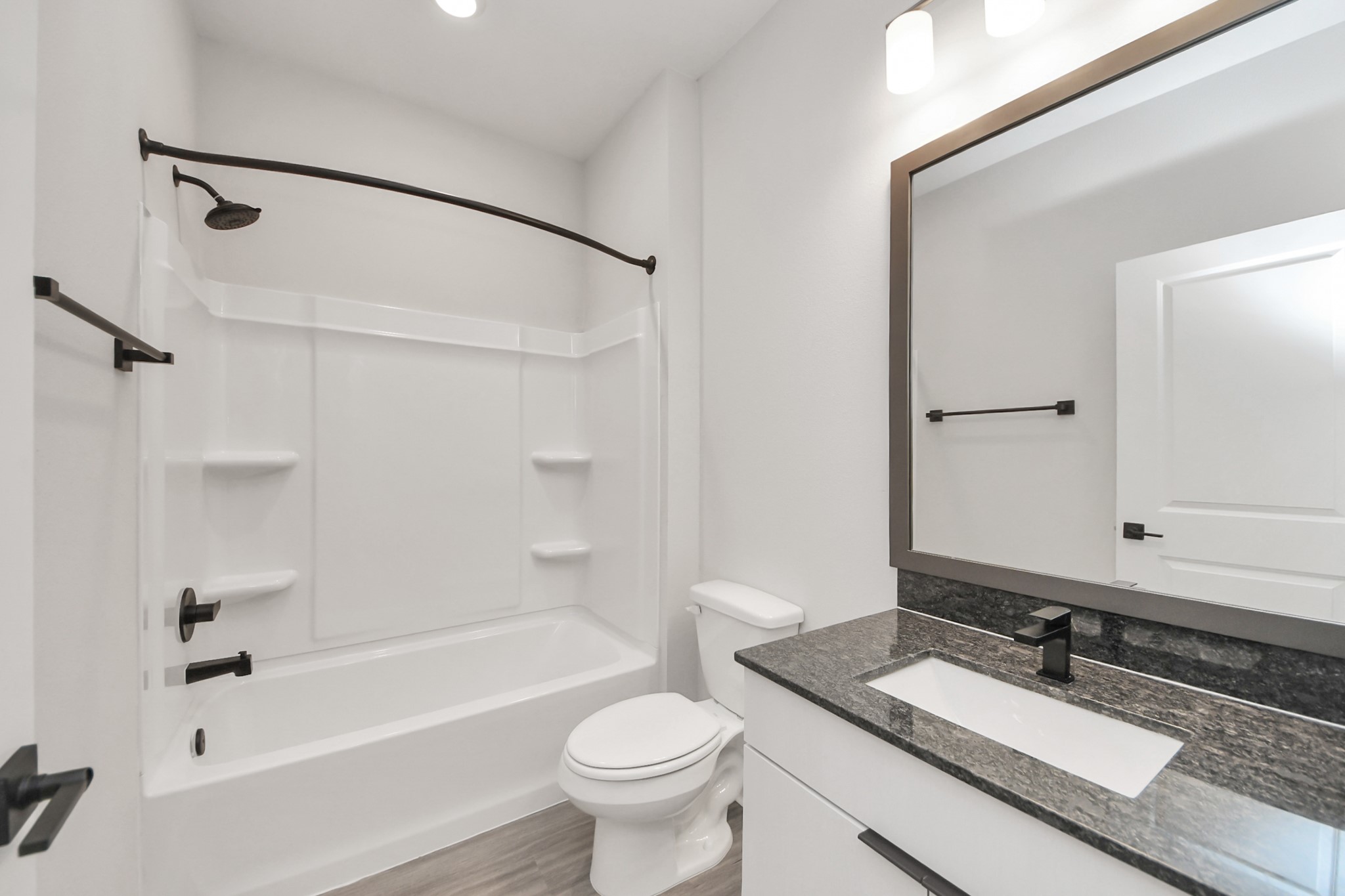 7711 Longmire Road, Unit 102 Conroe, TX 77304 - Photo 11 of 48 a bathroom with a granite countertop sink toilet mirror and shower