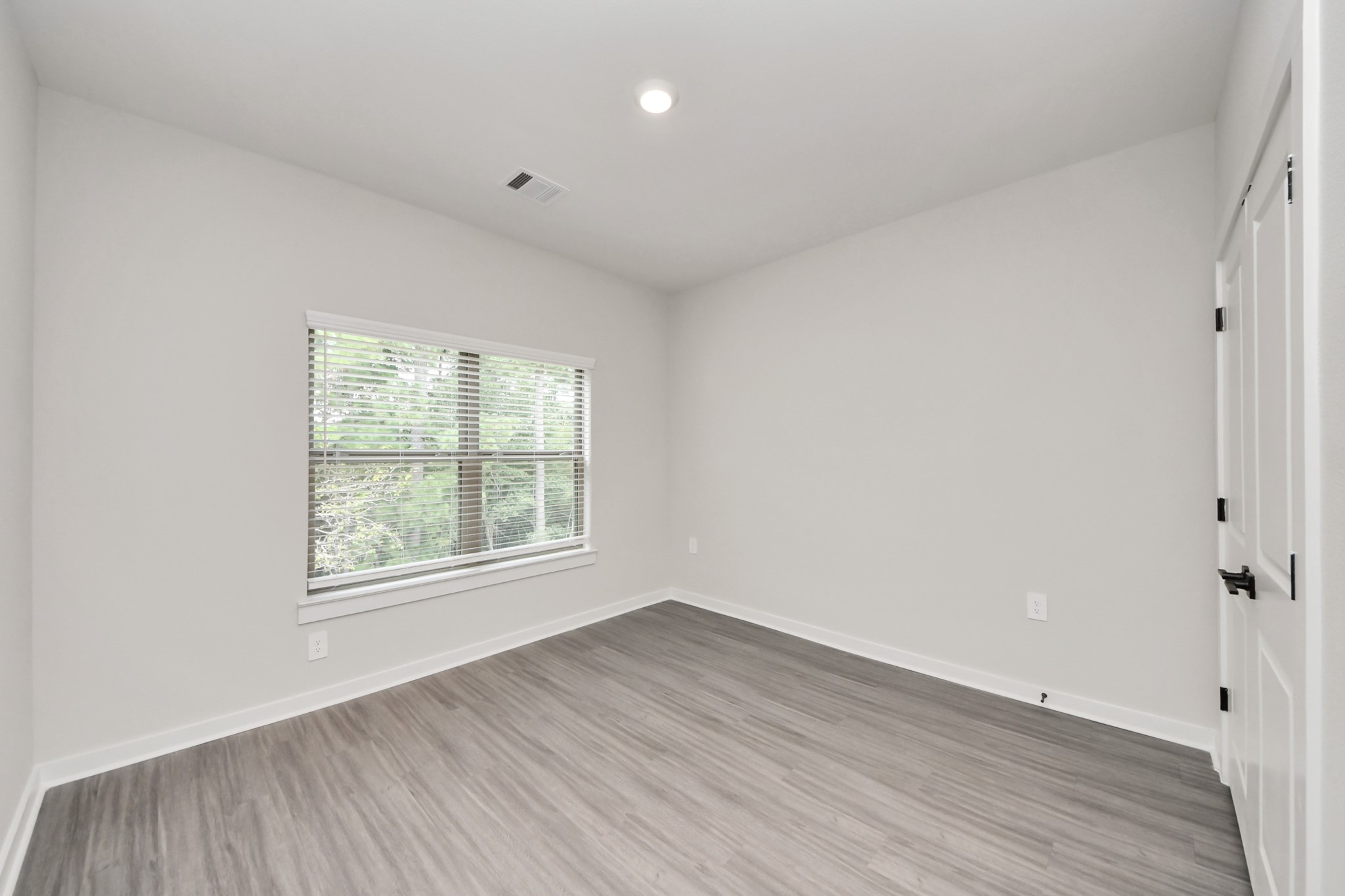 7711 Longmire Road, Unit 102 Conroe, TX 77304 - Photo 12 of 48 an empty room with wooden floor and windows