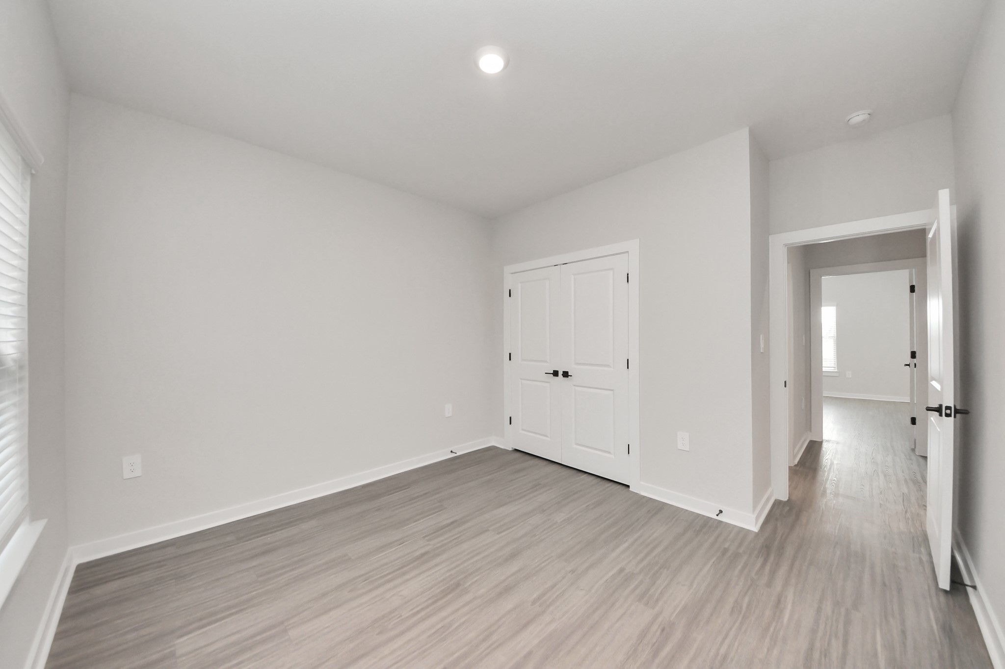 7711 Longmire Road, Unit 102 Conroe, TX 77304 - Photo 13 of 48 a view of a room with wooden floor and a ceiling fan
