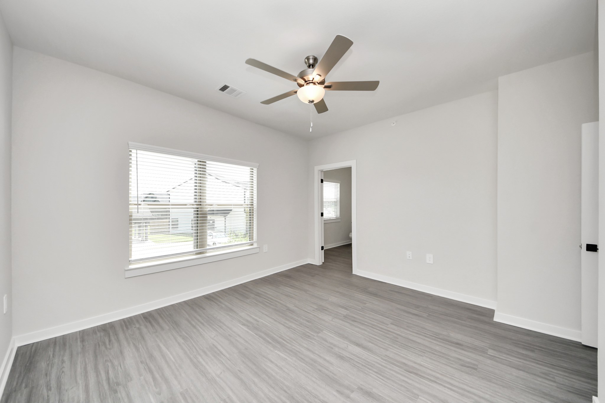 7711 Longmire Road, Unit 102 Conroe, TX 77304 - Photo 17 of 48 a view of an empty room with wooden floor and a window