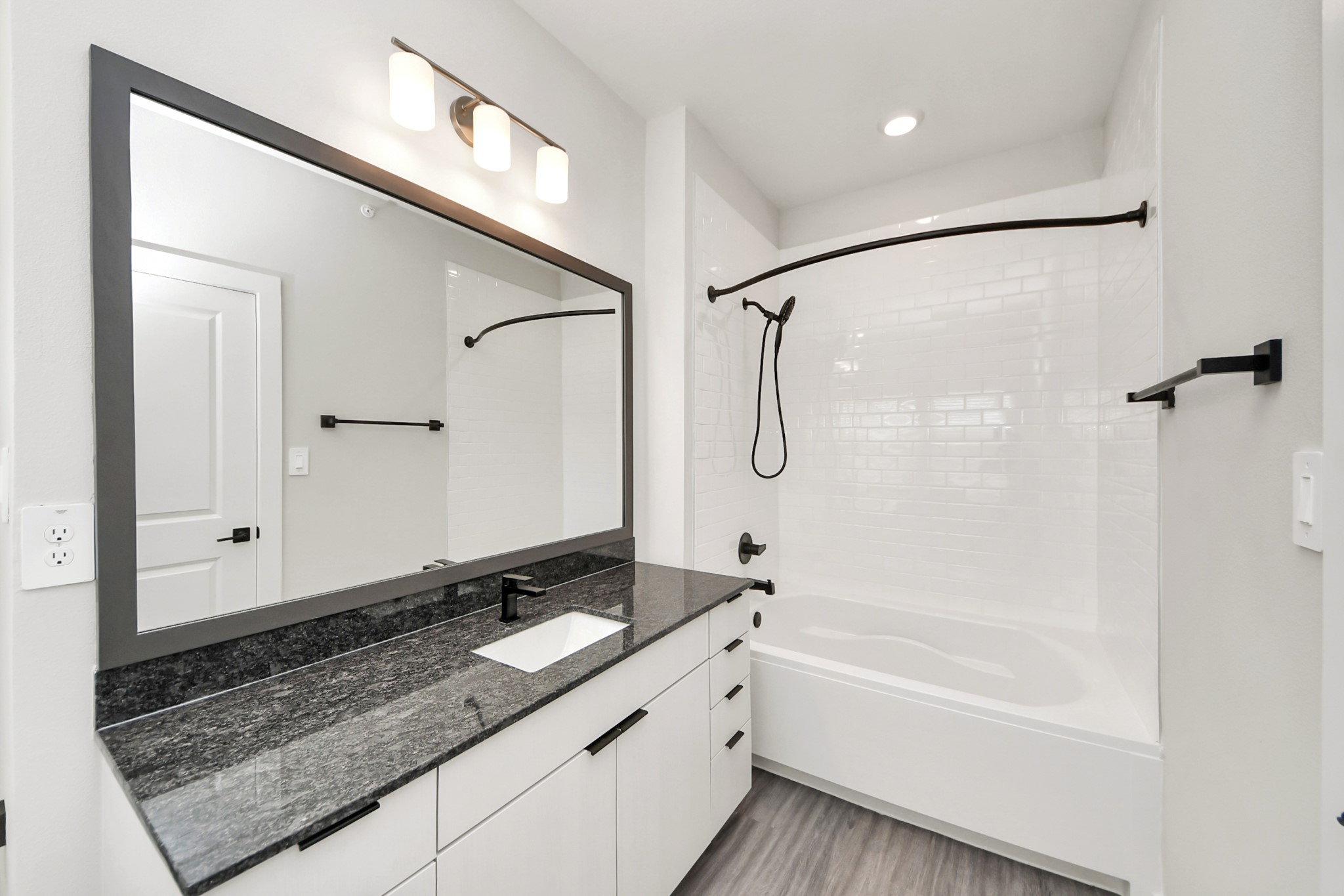 7711 Longmire Road, Unit 102 Conroe, TX 77304 - Photo 20 of 48 a bathroom with a granite countertop sink mirror bathtub and shower