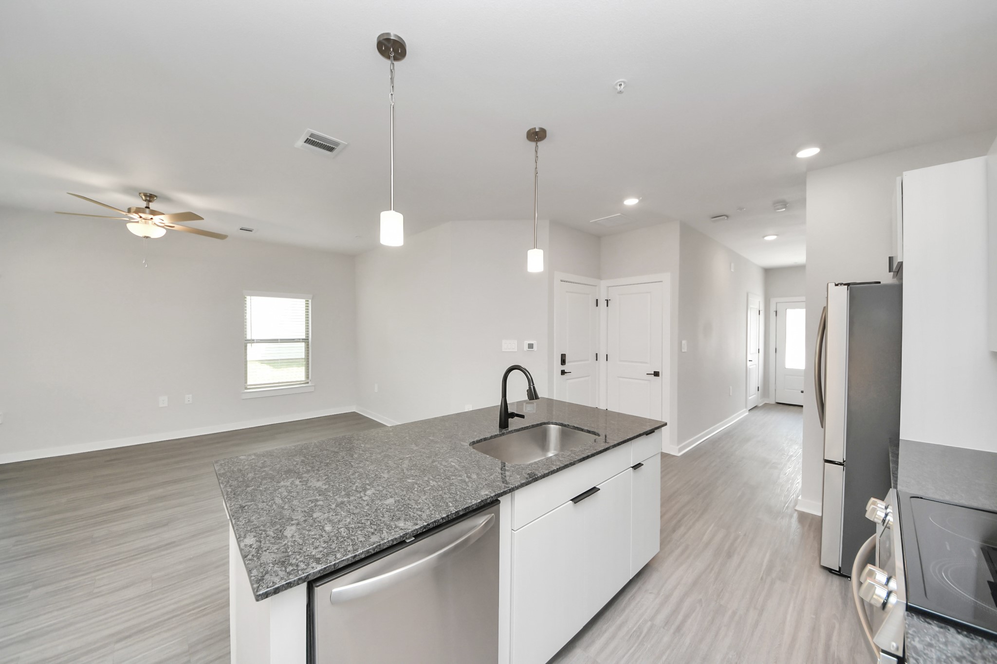 7711 Longmire Road, Unit 102 Conroe, TX 77304 - Photo 41 of 48 a kitchen with a sink chandelier and refrigerator