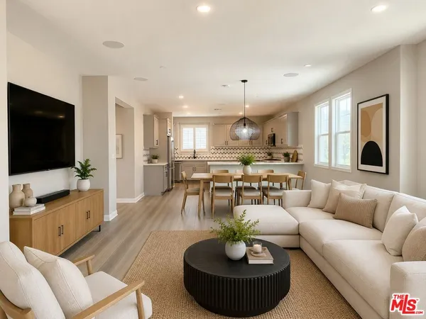 a living room with furniture kitchen view and a flat screen tv