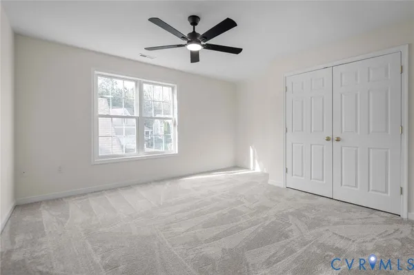 an empty room with a window and a fan
