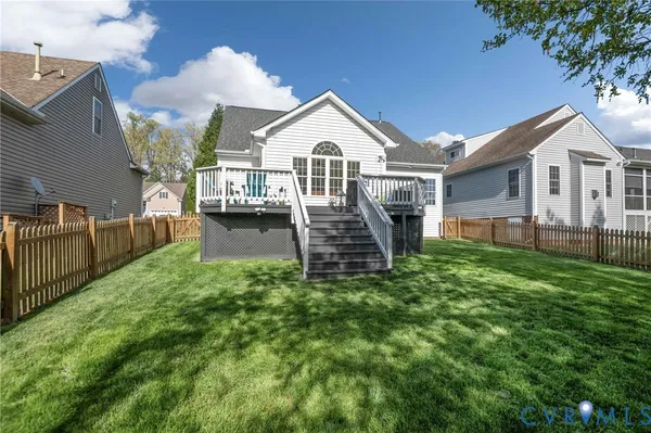 a view of a deck with wooden floor and fence with a yard