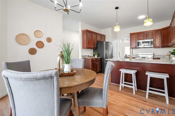 a kitchen with stainless steel appliances granite countertop a stove top oven a refrigerator a sink dishwasher and white cabinets with wooden floor