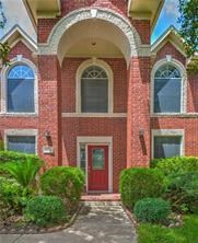 front view of a brick house with a small yard