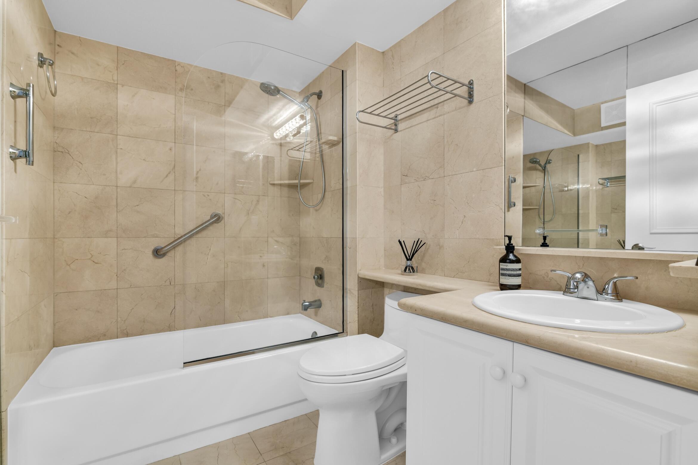 277 North Ocean Boulevard, Unit 1010 Boca Raton, FL 33432 - Photo 11 of 30 a bathroom with a sink a toilet and shower