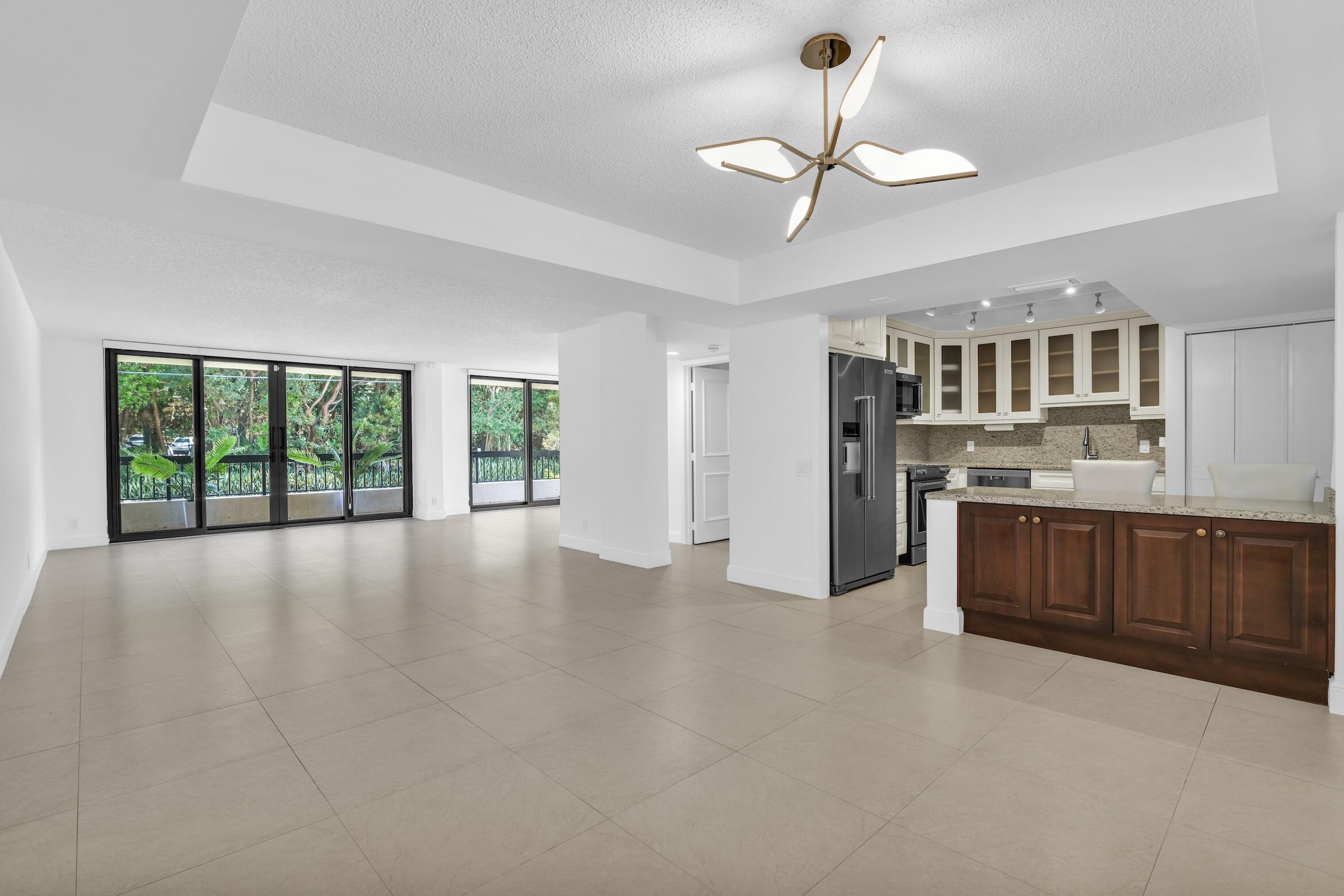 277 North Ocean Boulevard, Unit 1010 Boca Raton, FL 33432 - Photo 2 of 30 a view of kitchen with stainless steel appliances granite countertop a stove top oven a sink with dishwasher and cabinets