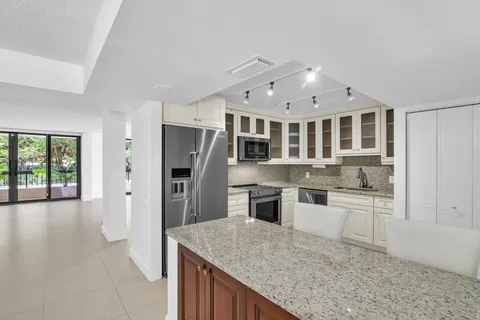 a kitchen with stainless steel appliances granite countertop a refrigerator and a sink