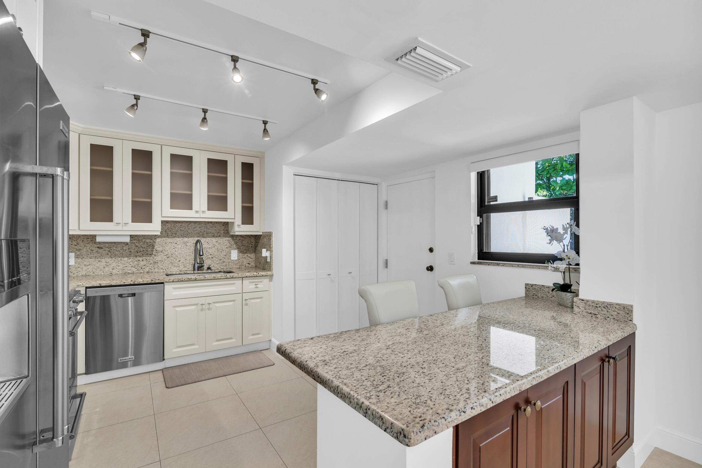277 North Ocean Boulevard, Unit 1010 Boca Raton, FL 33432 - Photo 9 of 30 a kitchen with granite countertop a sink and a refrigerator